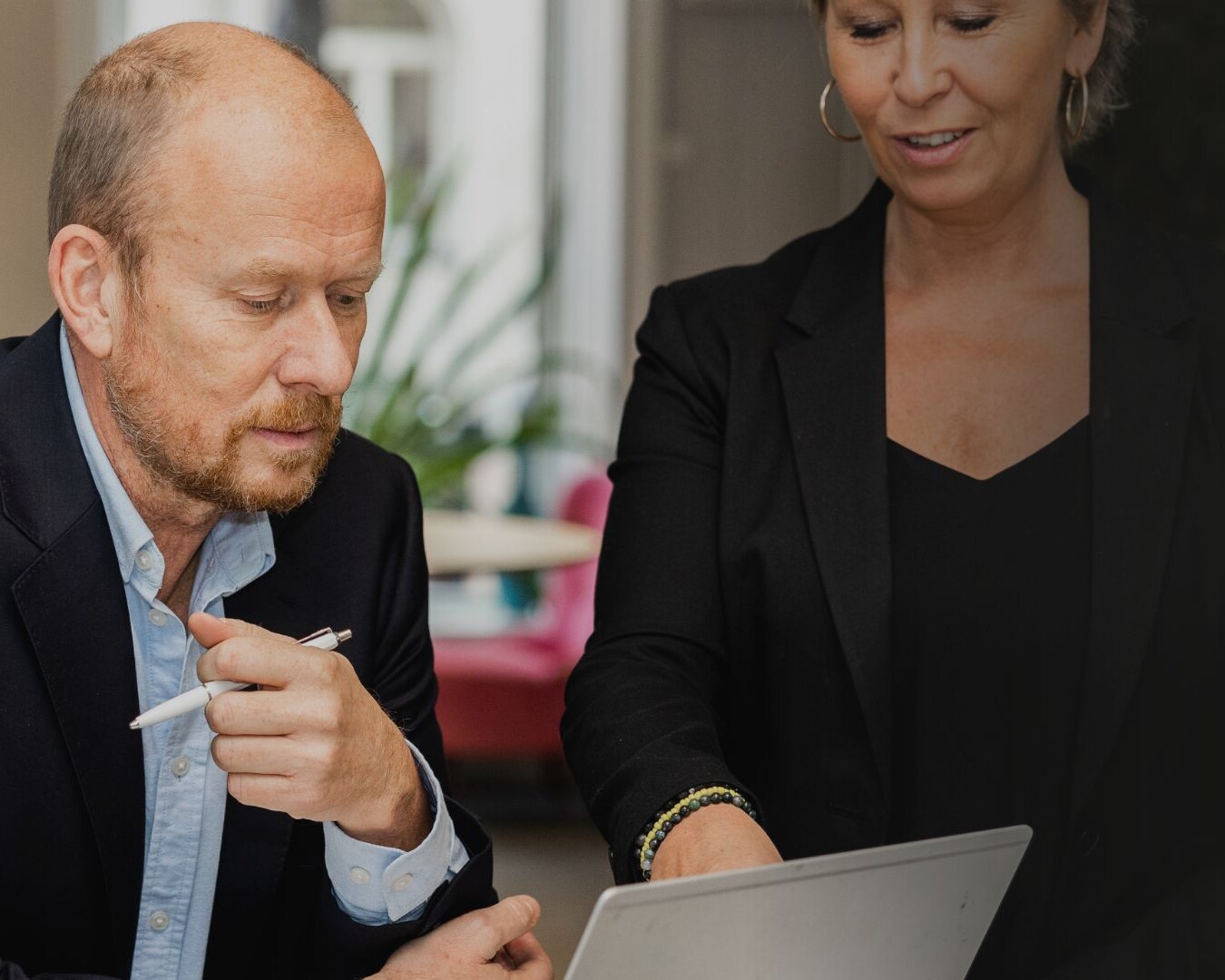 Roger sitter framför datorn med Anki bredvid till höger och pekar på datorn